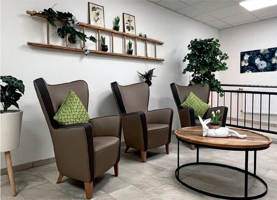 Im Lounge-Bereich stehen drei Ohrensessel und ein gemütlicher Couchtisch.